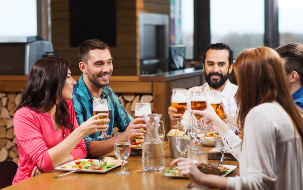 friends dining and drinking beer at restaurant - Foto, Imagem