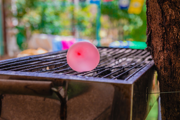 Balloon filled with water placed on a hot grill - Photo, Image