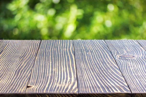 Wooden deck table over beautiful bokeh background - Photo, Image
