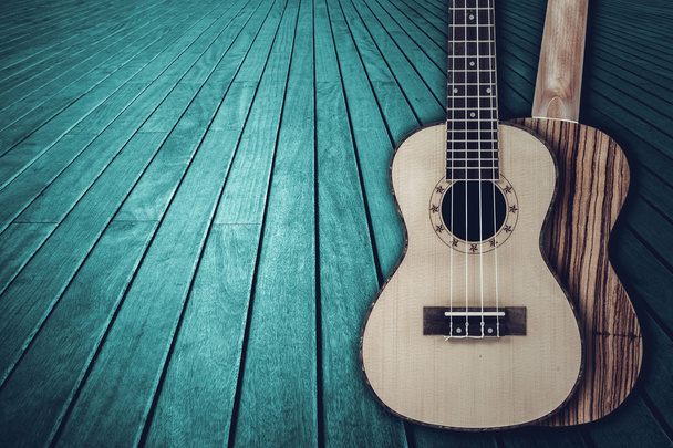 Parte de una guitarra acústica azul sobre un fondo de madera
. - Foto, imagen