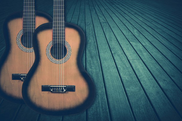 Deel van een blauwe akoestische gitaar op een houten achtergrond. - Foto, afbeelding