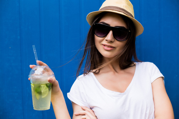 Μόδα όμορφη γυναίκα με λεμονάδα ή φρέσκο σε γυαλιά ηλίου και το καπέλο - Φωτογραφία, εικόνα