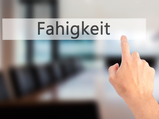 Fahigkeit (Ability in German) - Hand pressing a button on blurre - Foto, Bild