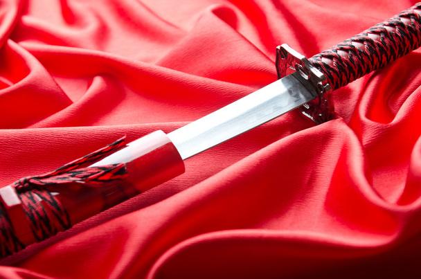 Japanese sword takana on red satin background - Fotografie, Obrázek