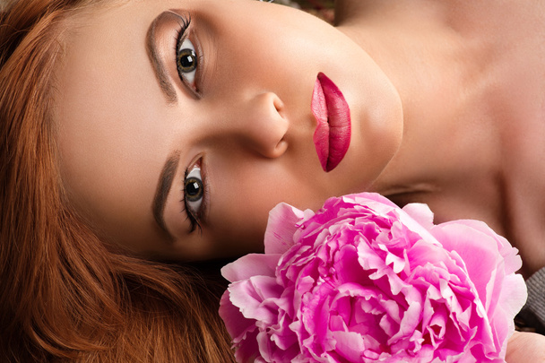 hermosa mujer con maquillaje de moda con peonía rosa
 - Foto, imagen