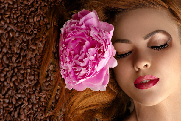 beautiful woman face with peony on coffee beans - Photo, Image