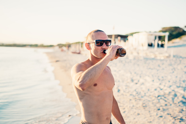 homem desportivo com óculos de sol bebendo cerveja
 - Foto, Imagem