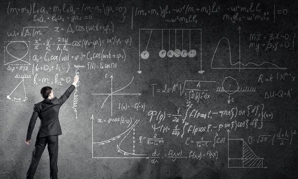 Teacher writing formulas on blackboard - Photo, Image