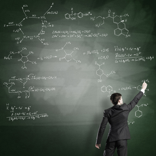 Scientist writing formulas on chalkboard - Fotó, kép