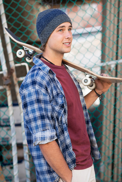 Handsome guy with skateboard - Photo, image