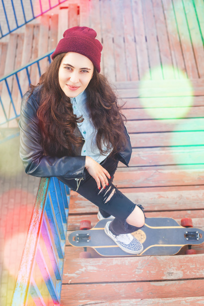 Hipster skateboarder girl with skateboard standing outdoor - 写真・画像