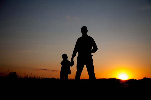 Силуэт отца и сына, держащихся за руки на закате
 - Фото, изображение