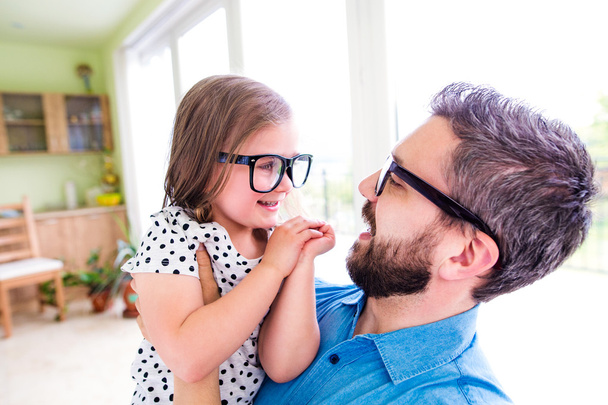 Father with his little daughter in black hipster eyeglasses - Fotó, kép