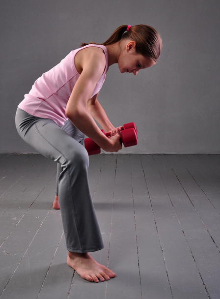 retrato de niña adolescente deportista haciendo ejercicio con pesas
 - Foto, imagen