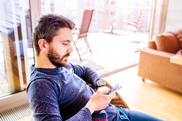 Man working from home using smart watch, living room - Photo, Image