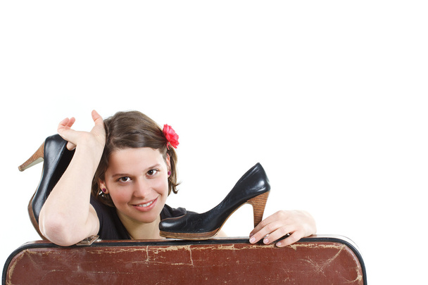 Девушка с обувью в руках за чемоданом
 - Фото, изображение