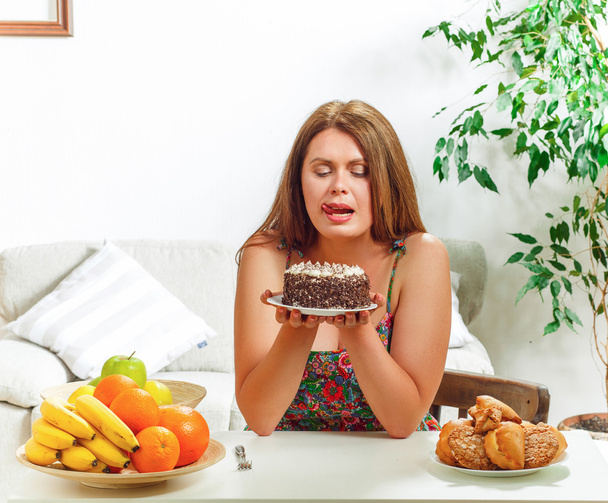 Lihava nainen istuu pöydässä kotona
 - Valokuva, kuva