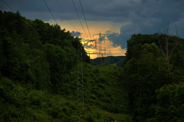 Valle con postes eléctricos en arbustos verdes
 - Foto, Imagen