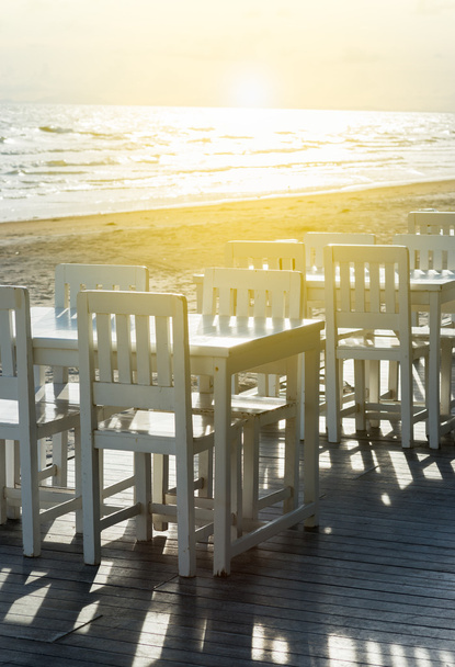 білий стілець і стіл на пляжі
 - Фото, зображення