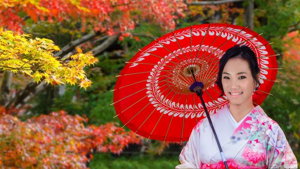 Nuori japanilainen nainen japanilaisessa puutarhassa syksyllä
 - Valokuva, kuva