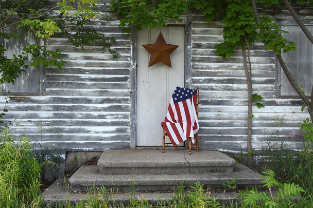 American flag by old house door - 写真・画像
