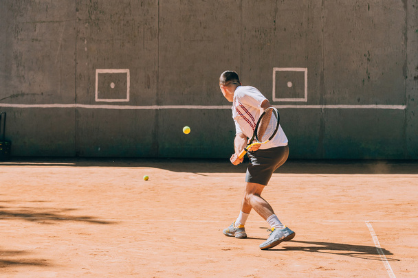 Jugador de tenis entrenando al aire libre
 - Foto, Imagen