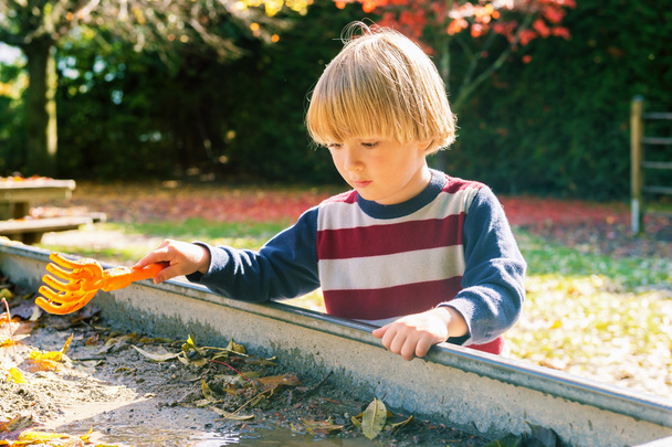 Little boy playing in muddy sandbox - Photo, Image