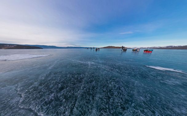 Tourists make the transition ice on Lake Baikal ice at sunset. W - Фото, изображение