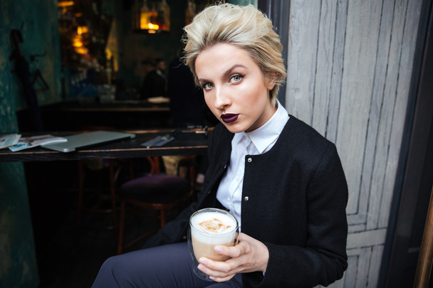 Portrait of stylish woman alone sitting at cafe - Fotoğraf, Görsel