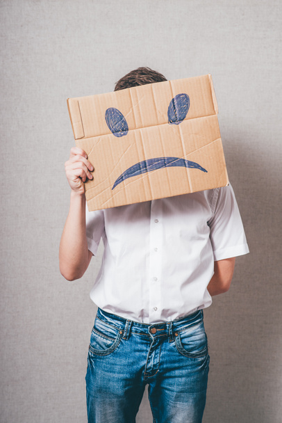 Hombre sosteniendo papel de cartón con smiley
 - Foto, Imagen