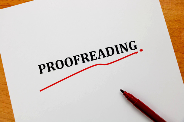 proofreading word on white sheet with red pen - Photo, Image