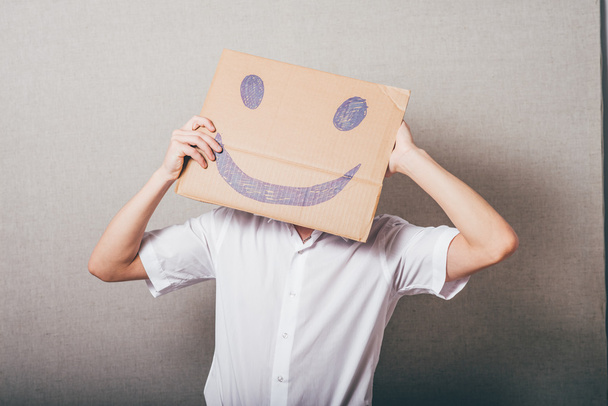 man holding a cardboard with a smiley  - Foto, imagen