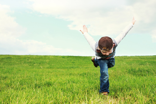 Niño jugando en un campo
 - Foto, Imagen