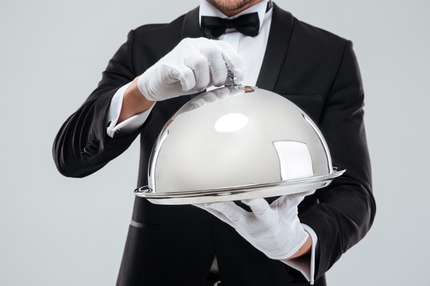Serving tray with cloche holded by butlers hands in gloves - Foto, Imagen