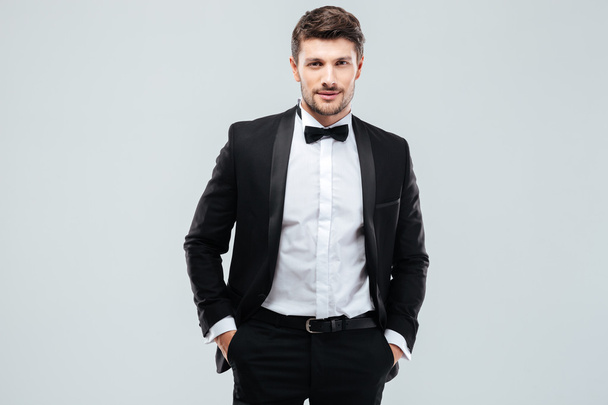 Confident young man in tuxedo with bowtie - Fotoğraf, Görsel