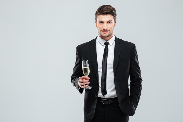 Confident man in suit and tie holding glass of champagne - Fotografie, Obrázek