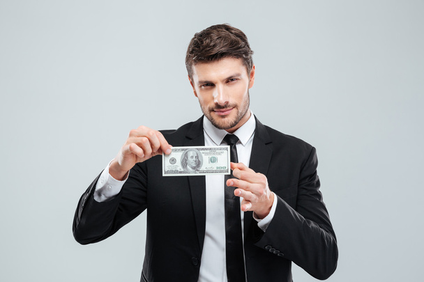 Attractive young businessman holding one hundred dollars banknote - Fotoğraf, Görsel