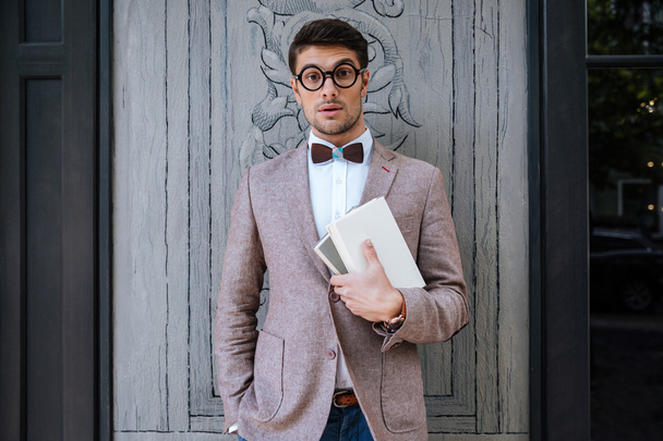 Young fashion man with nerd glasses and stylish hairdo posing - Fotó, kép