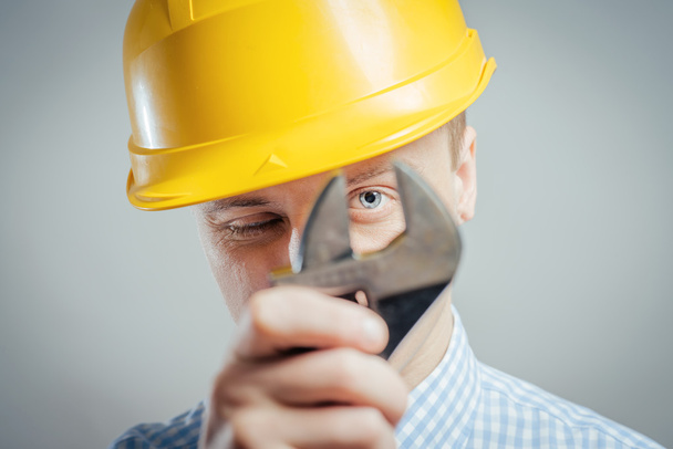 builder looking through a wrench - Foto, Imagem