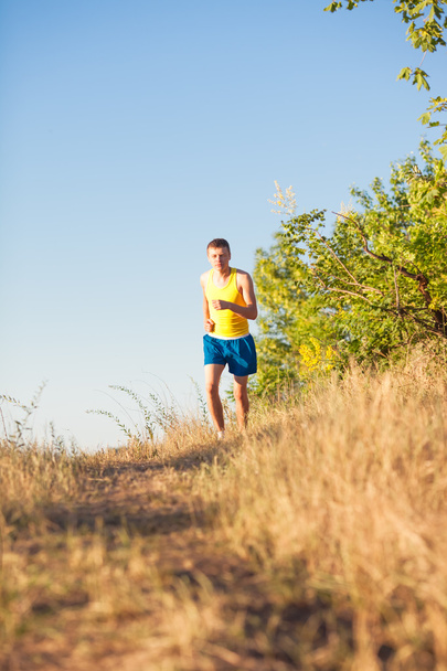 man running on a rural road  - Zdjęcie, obraz