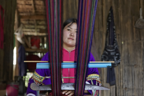 Thailand, Chiang Mai, Karen Long Neck hill tribe village (Kayan Lahwi), Karen woman in traditional costumes is making a carpet - Photo, Image