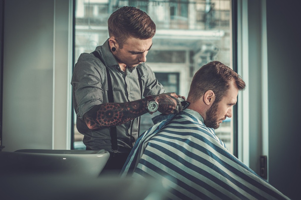 Uomo sicuro di sé in visita parrucchiere in negozio di barbiere
. - Foto, immagini