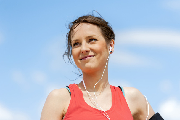 Вмістити жінку бігун відпочиває після бігу прослуховування музики
. - Фото, зображення