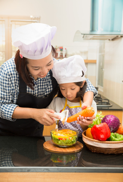 Aziatische moeder onderwijs dochter salade maken in de keuken, koken Cooking concept van gelukkig Aziatische klein meisje en moeder maken salade - Foto, afbeelding
