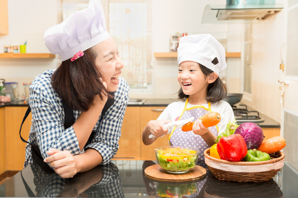 Asian mother teaching daughter making salad in kitchen,Cooking  Cooking  concept of happy asian little girl and mother making salad - Photo, Image