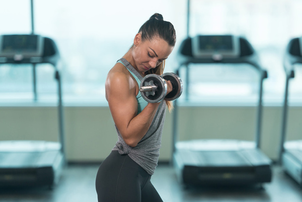 Young Woman Doing Biceps Exercise With Dumbbells - Foto, Imagen