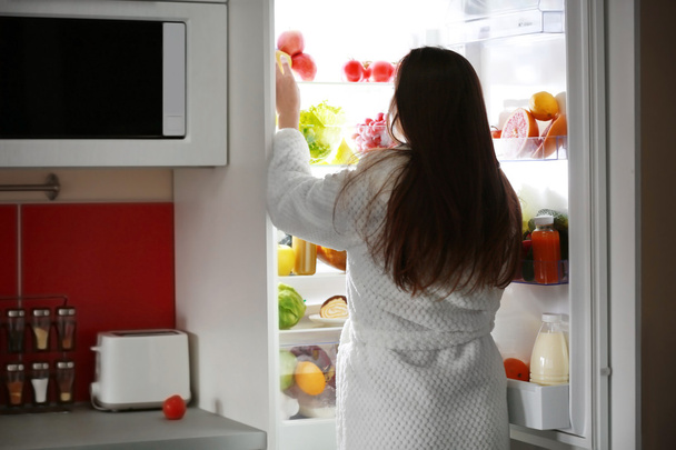 Young woman and fridge - Foto, Imagen
