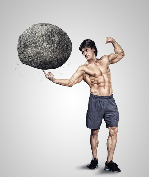macho sosteniendo piedra grande
 - Foto, imagen