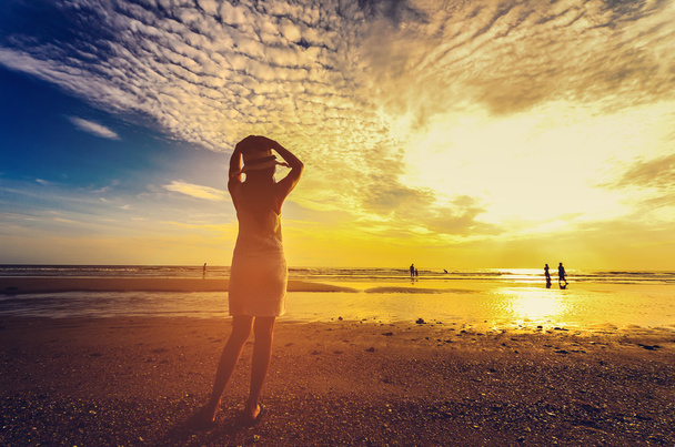young woman standing on sand and looking to a sky - Foto, Imagem