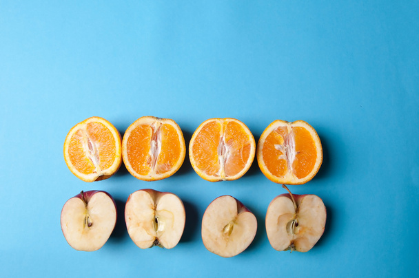 Oranges and apples on blue background - 写真・画像